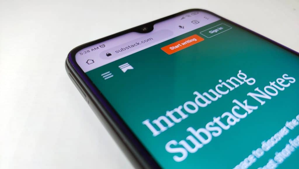 A cell phone with a blue screen introducing the new Substack Notes feature.