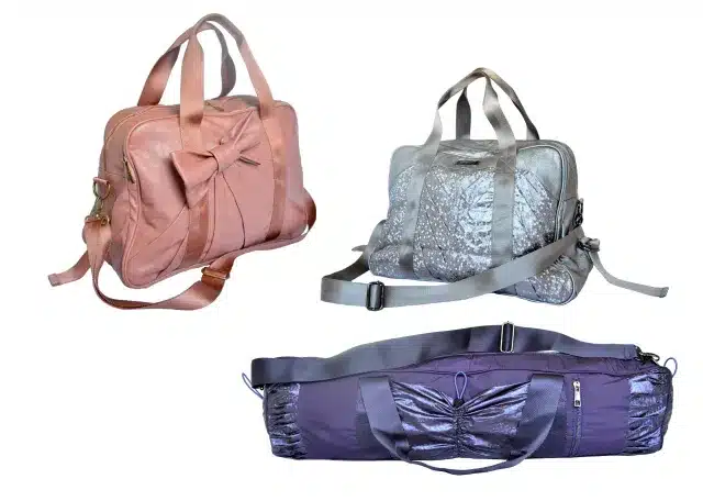 Display of the first 3 yoga bags Cassey Ho designed. The one of the top left is pink with a bow on it. The one of the top right is silver with glitter. And the one on the top right is blue with a metallic finish.