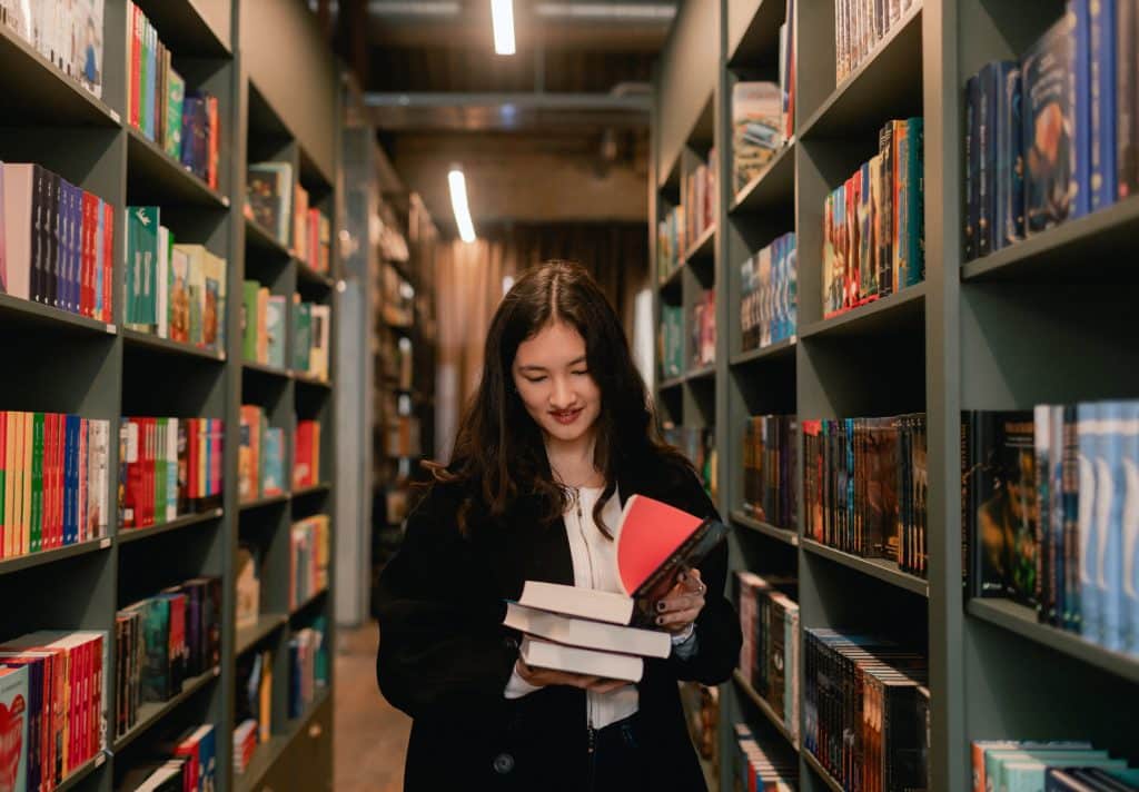 Girl at a bookstore with books in her hands
