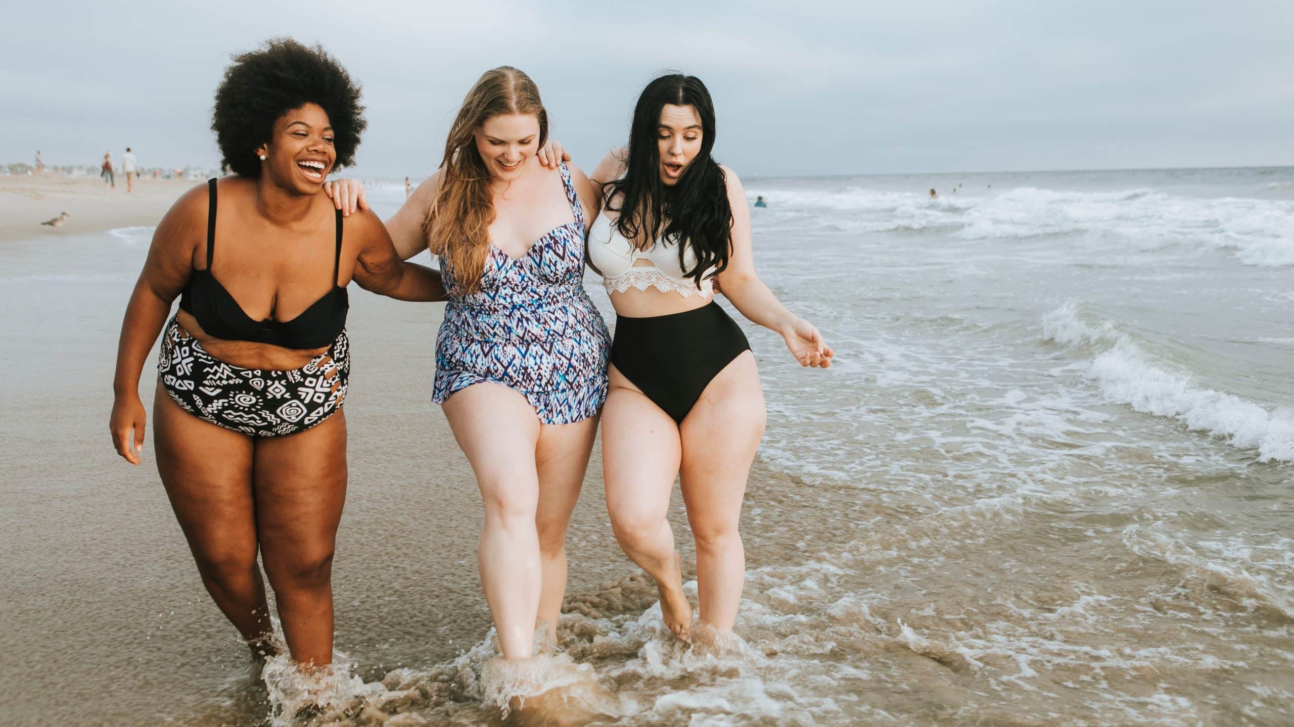 Three happy fat women on the beach