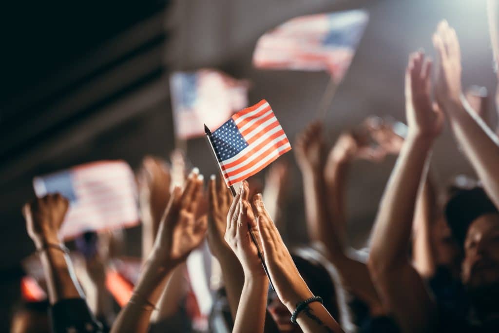 Crowd holding up American flags