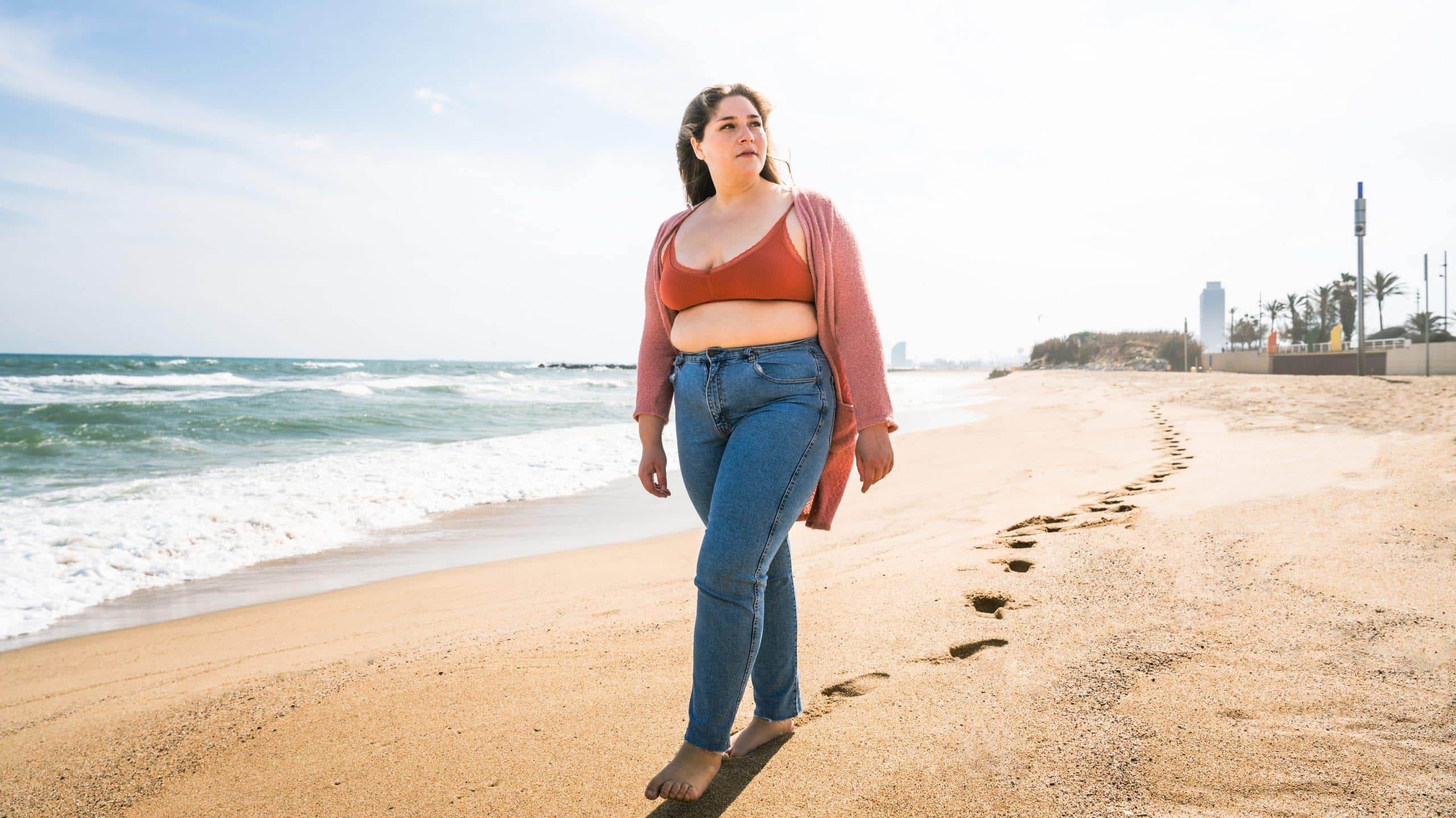 Pretty fat woman walking on the beach