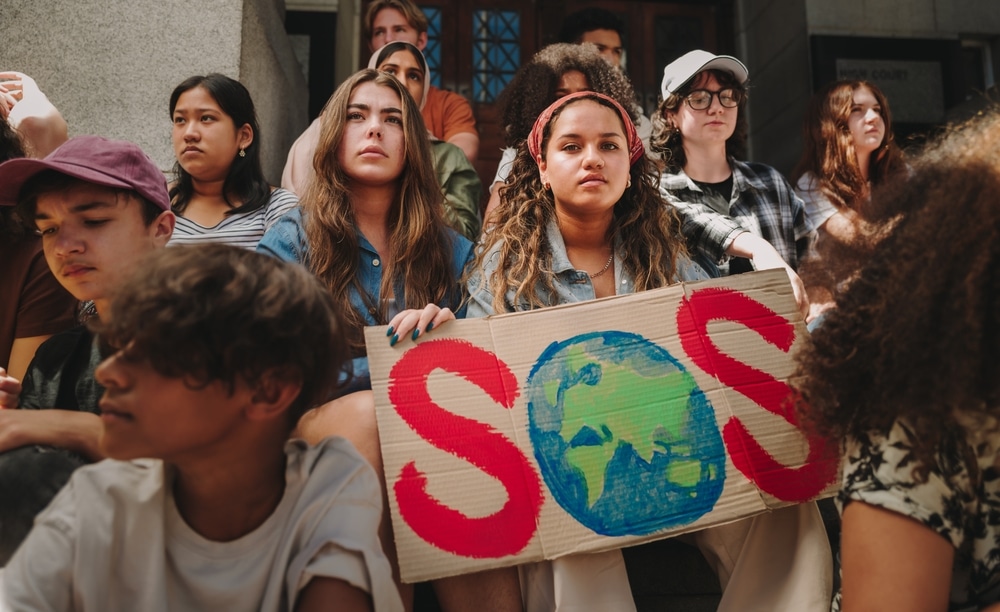 Climate activists hold up an "SOS" sign