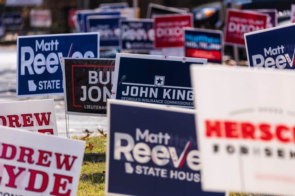 Various political campaign signs spread over a field