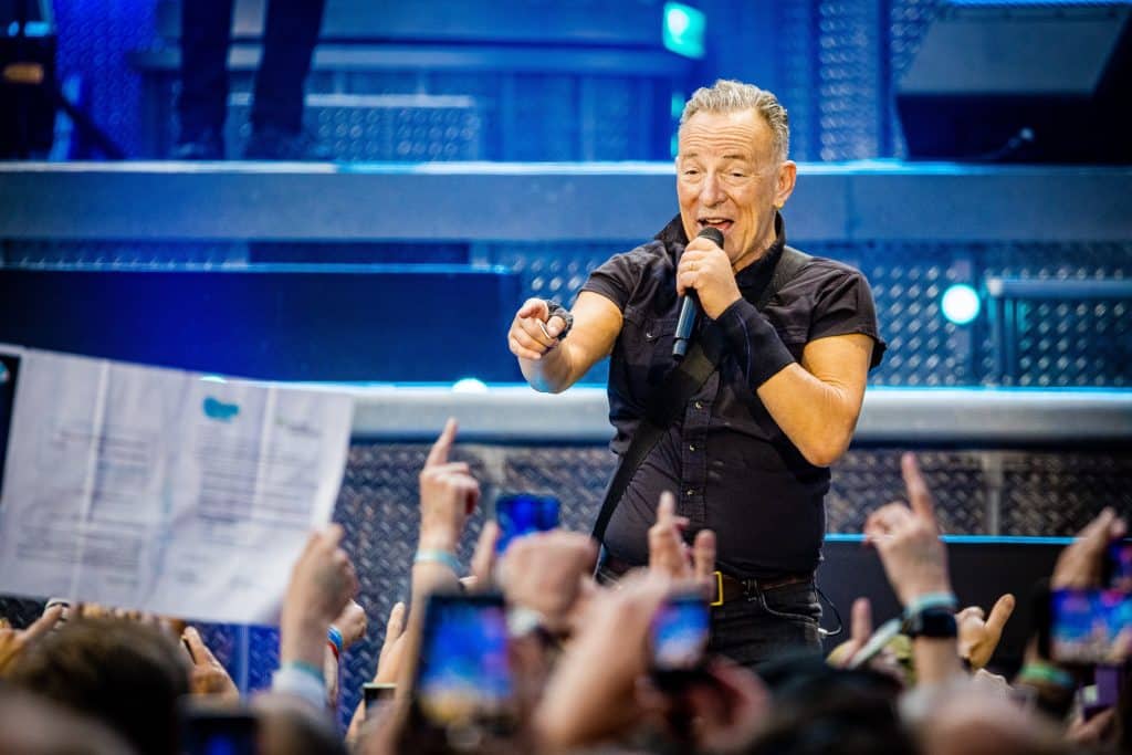 Rock star Bruce Springsteen performing in concert, pointing out to the crowd.