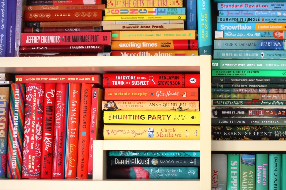 A section of a bookshelf that is color-coded