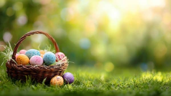 Easter Eggs sitting in a basket in the grass.