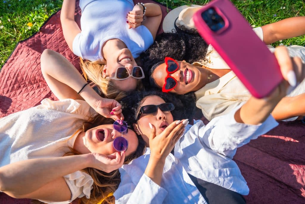 Group of friends with sunglasses taking a photo, 2000s life