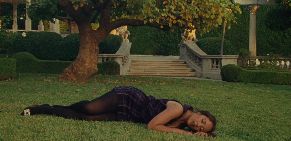 Laufey lying on the grass in the I wait, I wait, I wait music video.