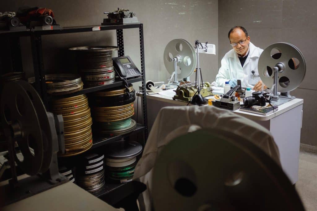 A technician sits in a lab and restores a film