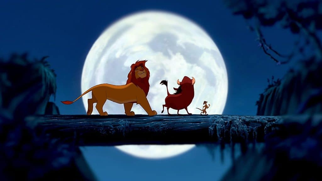 This image is a still from the animated Lion King showing Simba, Timon, and Pumba walking along a log.