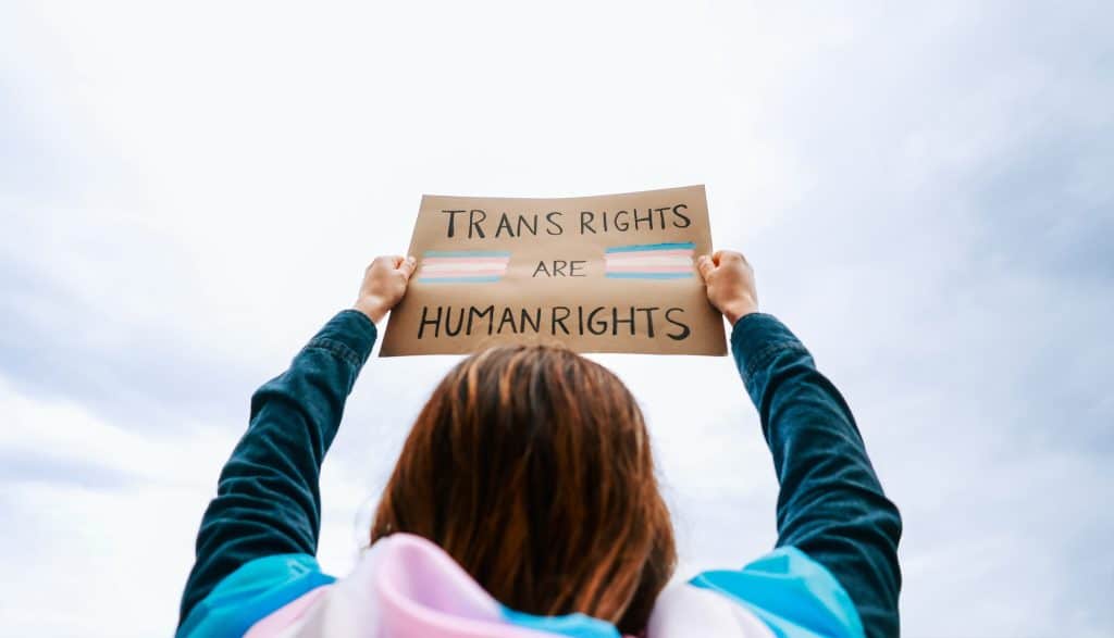 Protestor holds up a sign saying “Trans Rights Are Human Rights.”