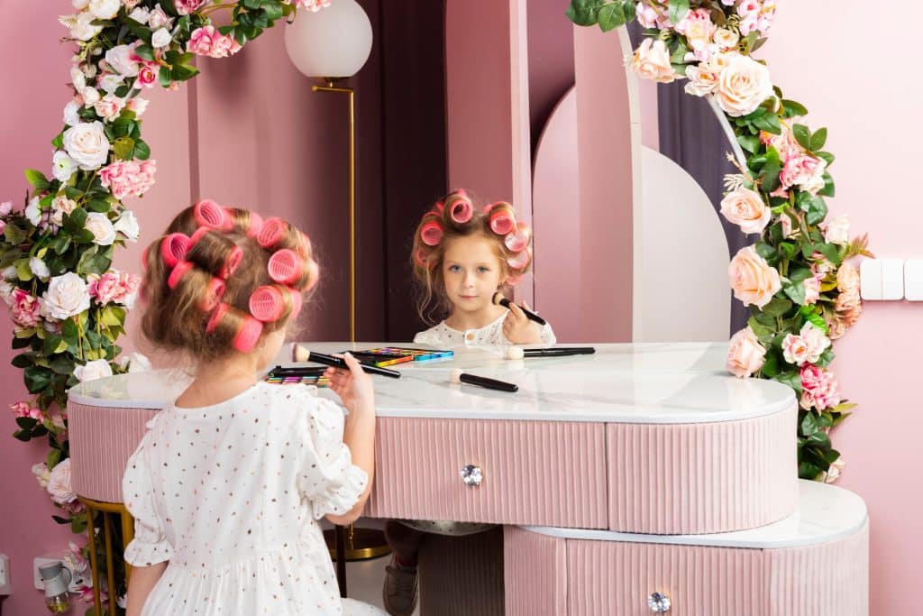 Little girl wearing hair rollers and white polka dot dress