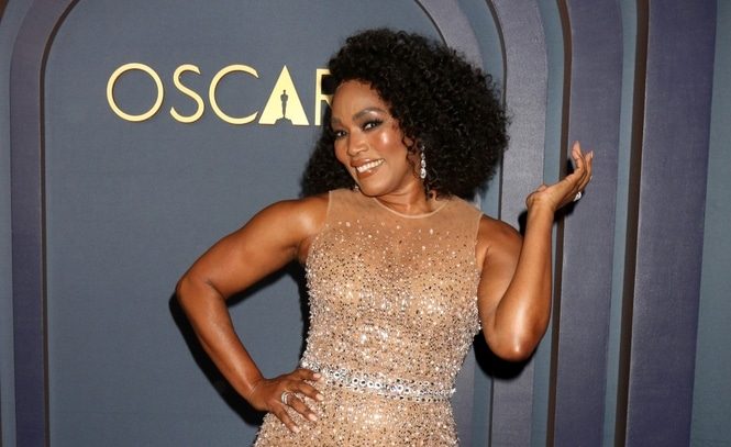 Angela Bassett in golden dress posing
