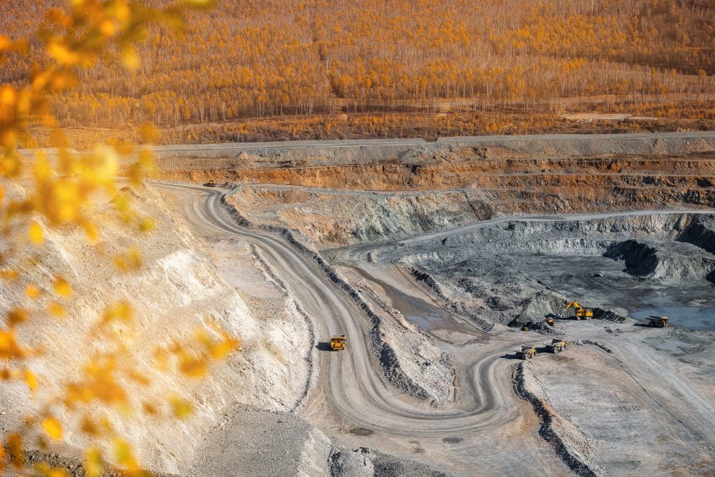 Mining with yellow-orange forest behind it.