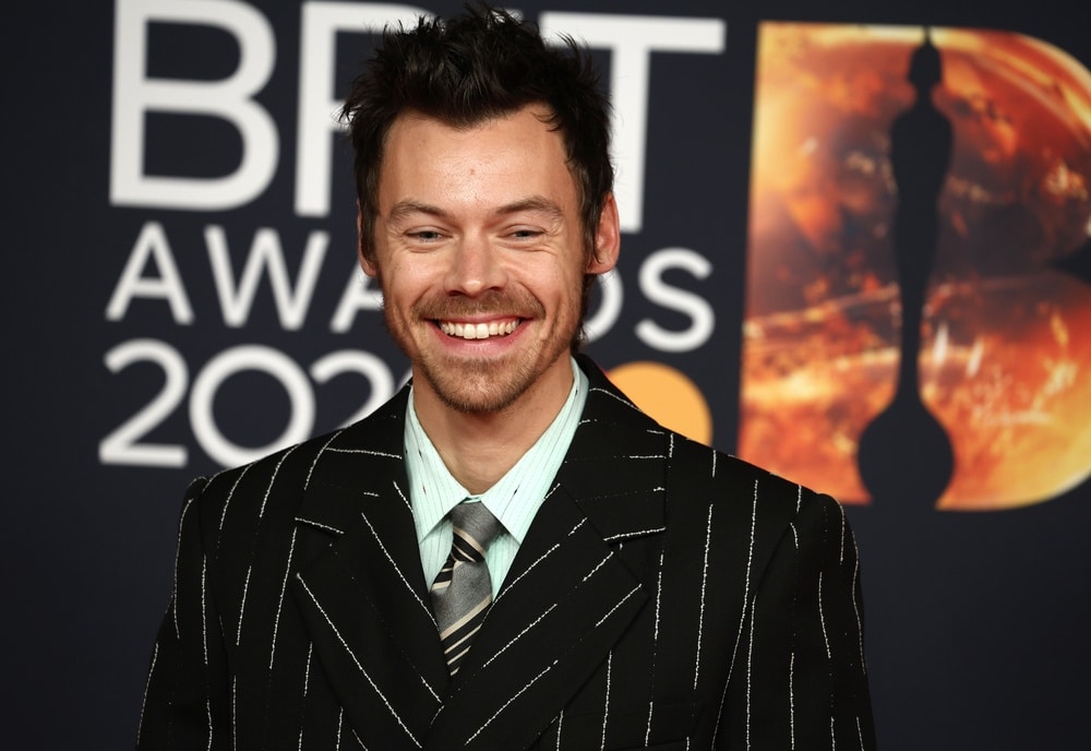 Harry Styles smiles in striped black tux