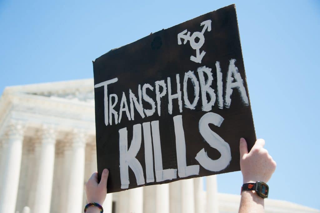 Sign stating "Transphobia Kills" in front of the supreme court during a protest for transgender rights