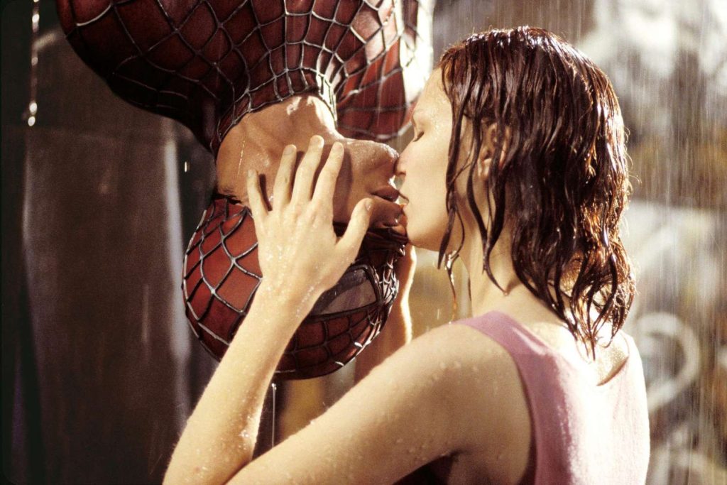 The image is a still from Spider-man, showing MJ and Spider-man kissing in the rain.