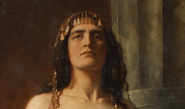 Partial image of a painting of Klytemnestra by John Collier, featuring her head and shoulders. She has olive skin, blackish hair, and brown eyes, a sharp nose, and strong brows and jawline. She gazes imperiously off to the side, as though challenging someone out of frame.