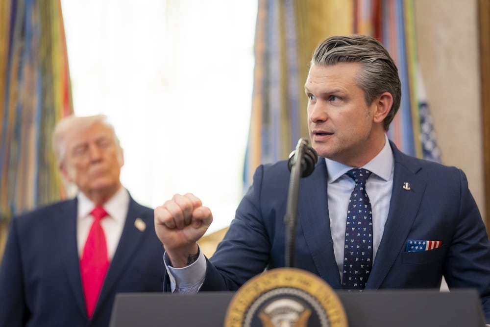 President Donald Trump standing behind former FOX host Pete Hegseth.