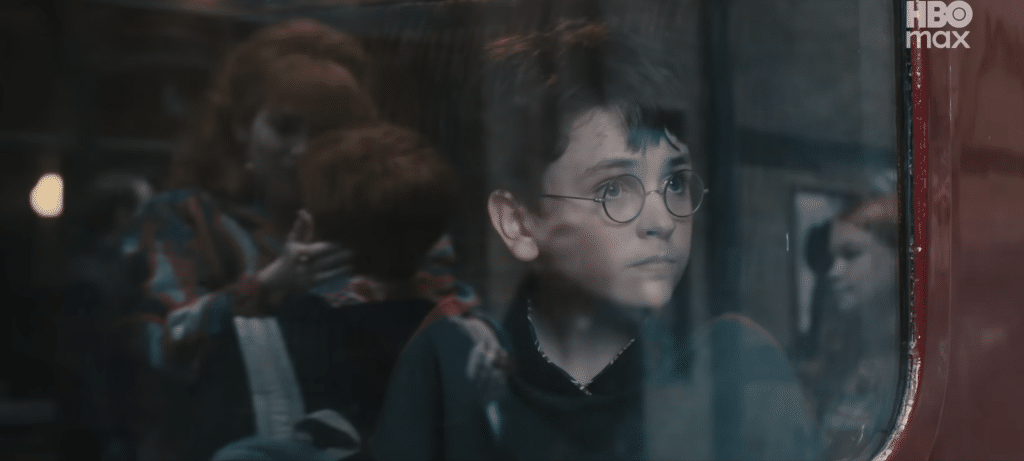 Harry looks out of the train at Ron and Molly with ginny appearing in the side of the frame