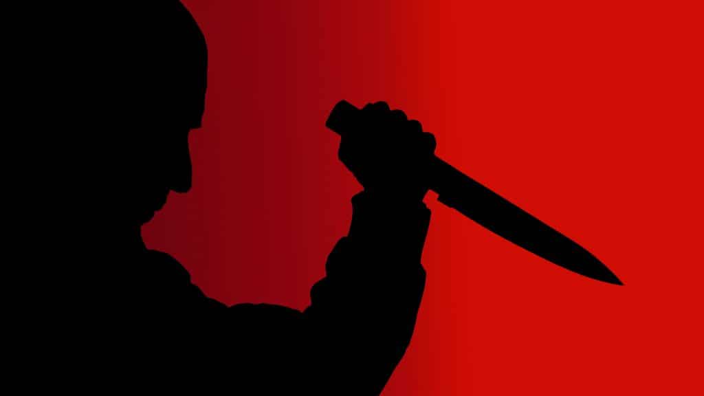Silhouette of a man with a knife against a red background.