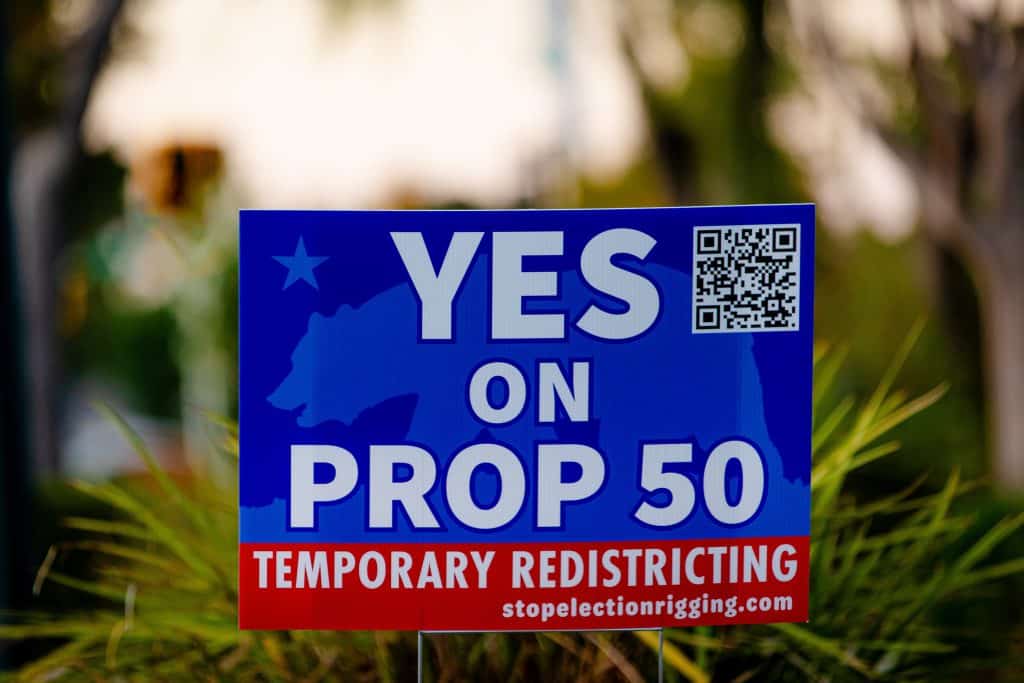 A blue and red "Yes" Prop 50 sign infront of grass