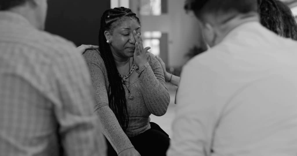 A woman crying in group therapy