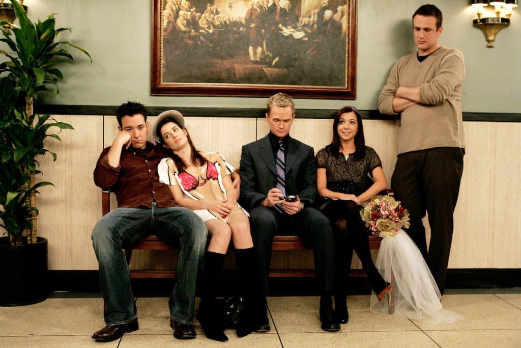 How I Met Your Mother characters Ted, Robin, Barney, Lily, and Marshall are sitting together.