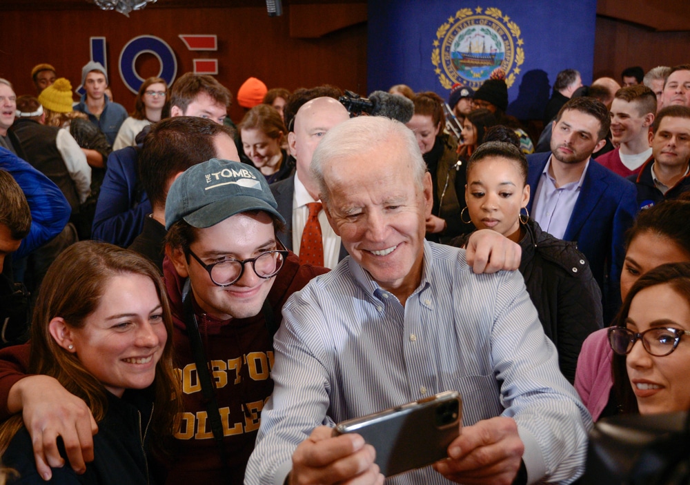 Joe Biden takes photos with a group of college age adults who may be perspective voters.