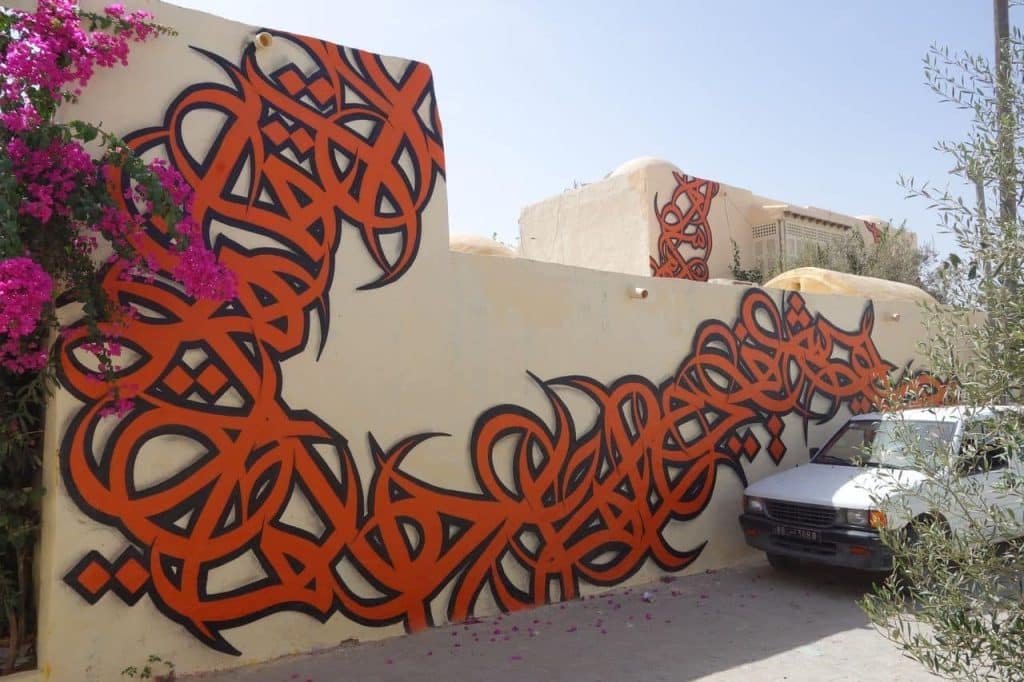 This image features a large orange-and-black calligraffiti piece.