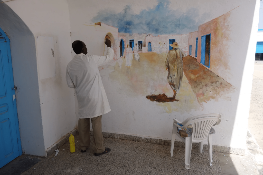 This image shows an artist refining his street artwork