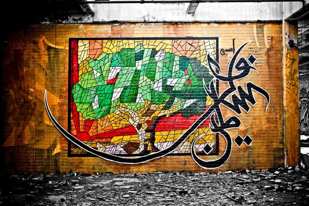 A tree image along with calligraffiti-style lettering next to it can be seen on a brick wall.