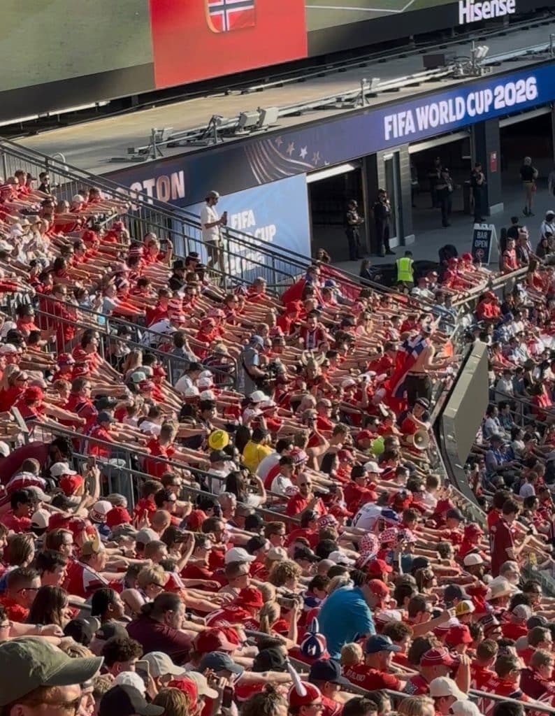 Thousands of Norwegian fans perform a synchronized rowing celebation, where all of their hands start outstretched and then they pull back to simulate a rowing motion.
