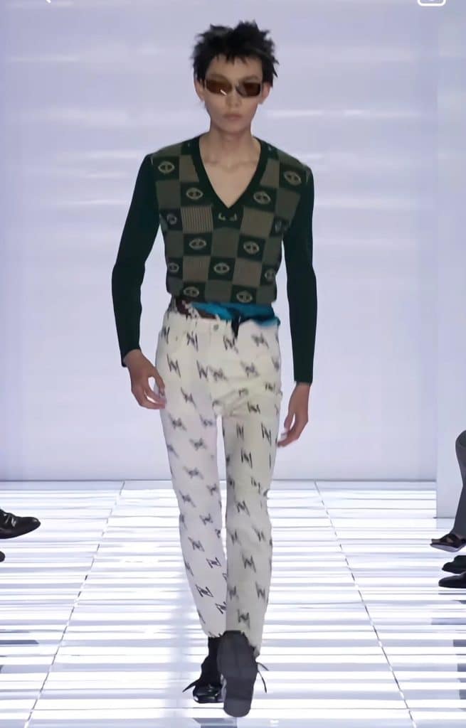 A screengrab from the Prada runway featuring a series of loud contrasting patterns. Still very skinny silhouette.