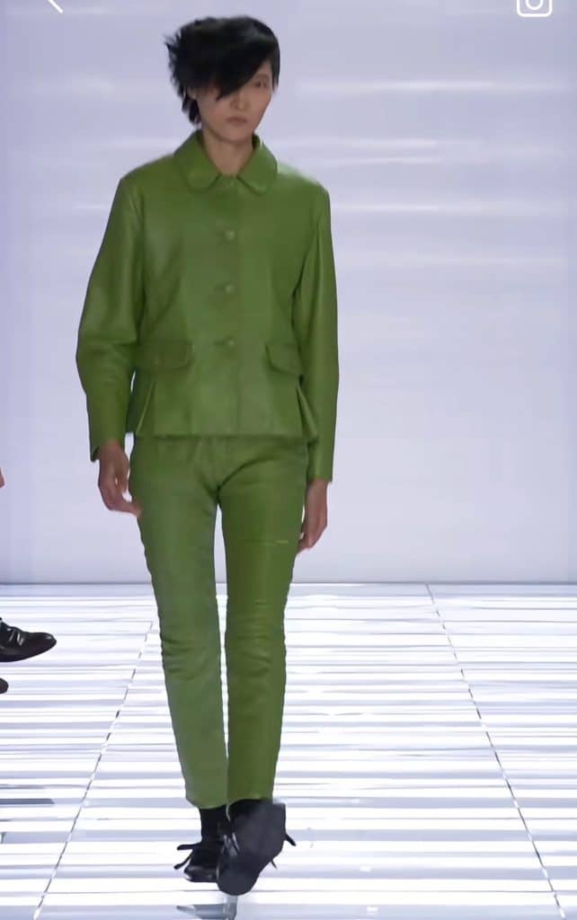 A screengrab from the Prada runway featuring an all-green, leather look that hugs the models body.