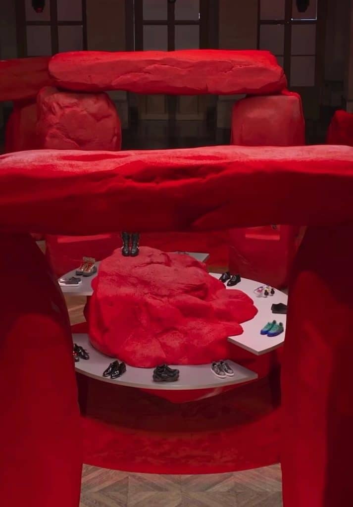 The set for this Christian Louboutin show which shows a recreation of stone henge, but all red, with shoes scattered around on display.