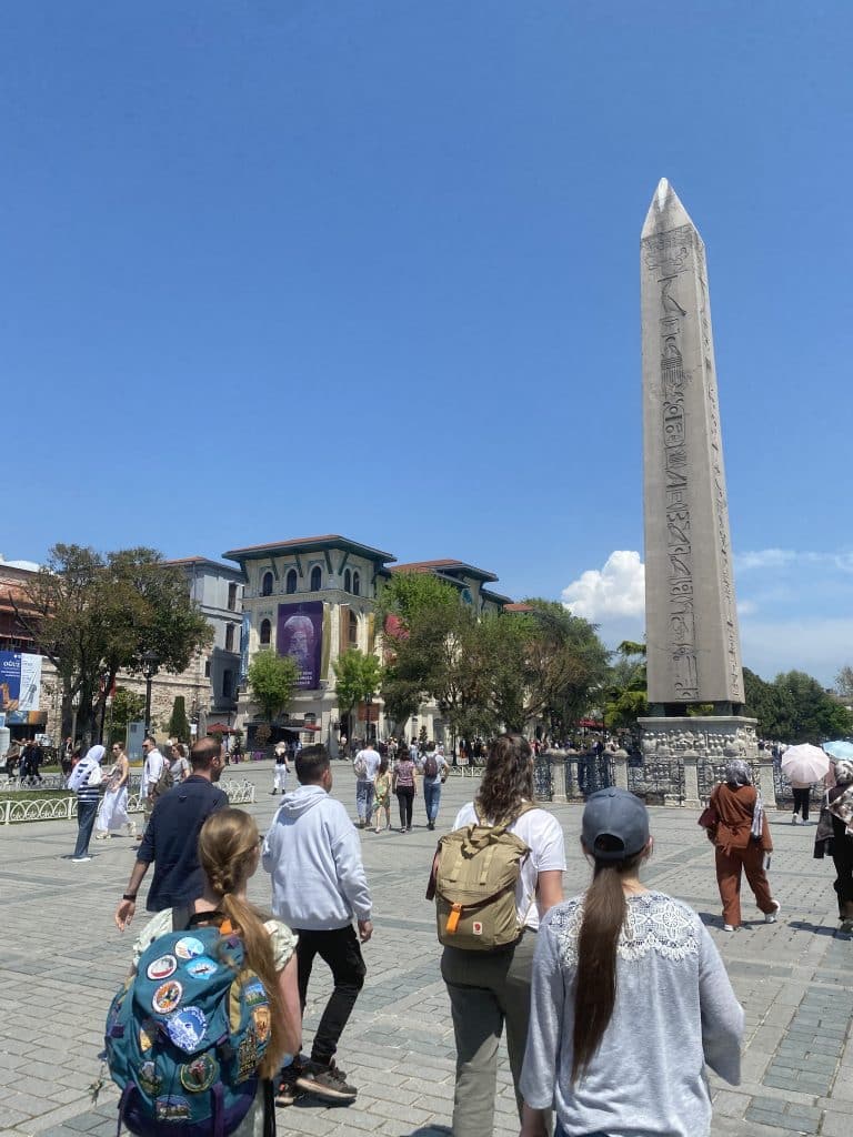 A group of students journeying in Istanbul, walking toward a spire.