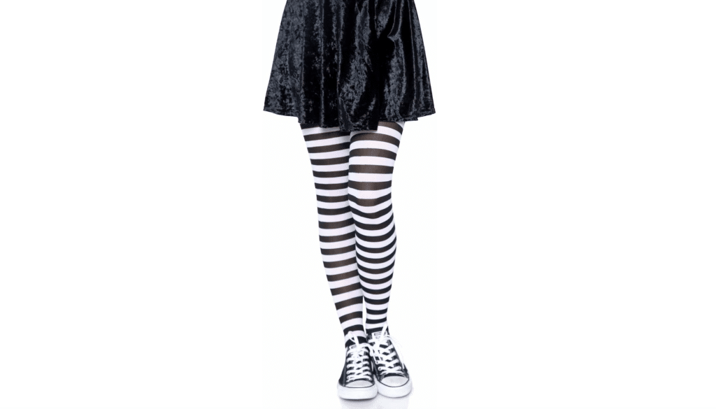 Tights are being modeled waist-down, against a white background. The tights contain alternating black and white horizontal stripes all throughout the clothing, and the tights are paired with a black mini skirt or dress and low-rise classic Chuck Taylor Converse.