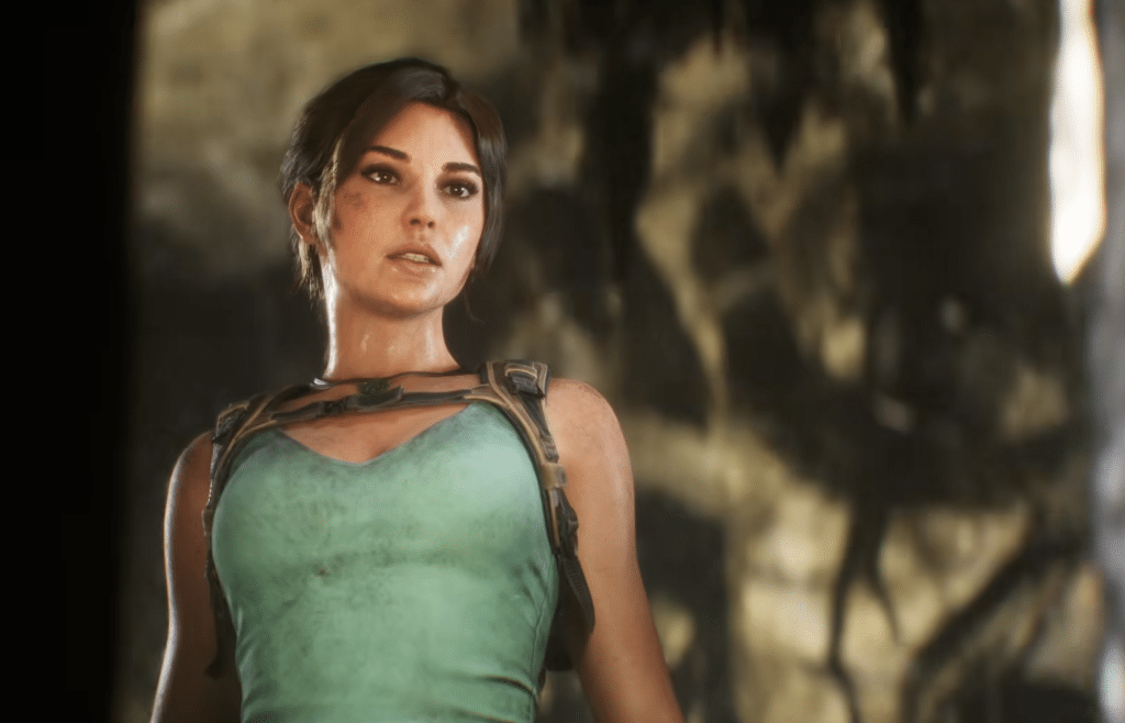 Lara Croft, clad in a teal tank top and harness, stares into the middle distance. She has brown hair and tan skin, and is slightly sweaty with a streak of mud on her cheek.