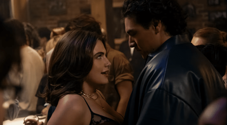 A woman on the left looking up at a man on the right at a party.