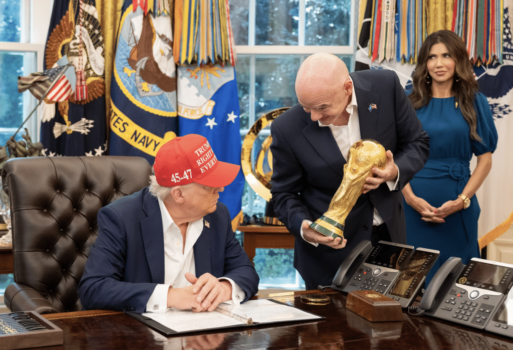 In the Oval Office, President Trump is shown the World Cup Trophy by FIFA President Gianni Infantino.