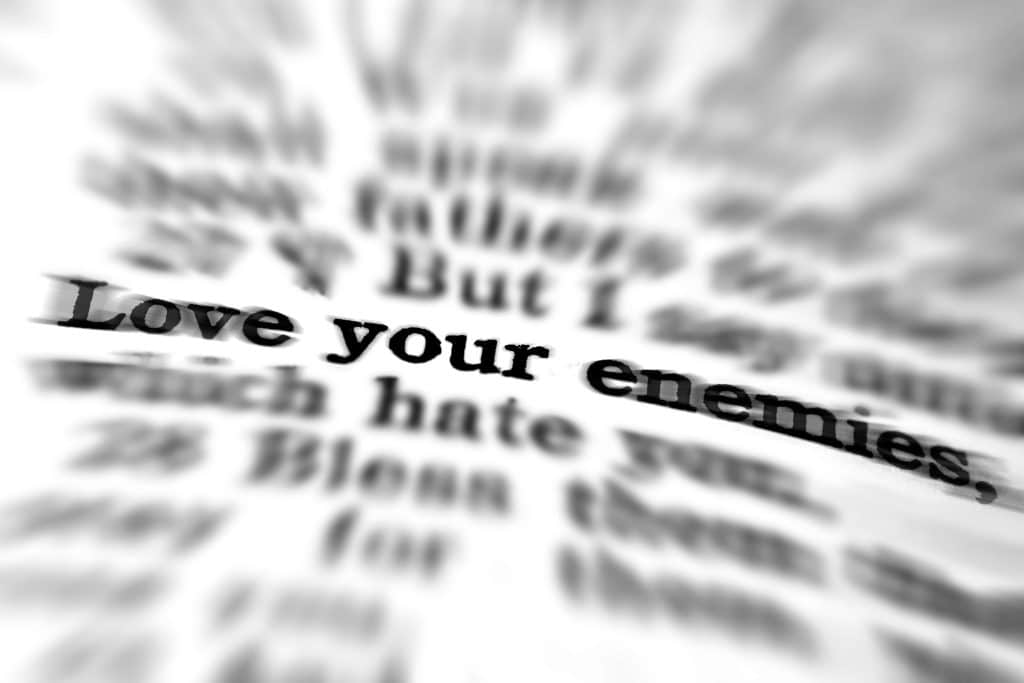 Close-up of book text saying, "Love your enemies."