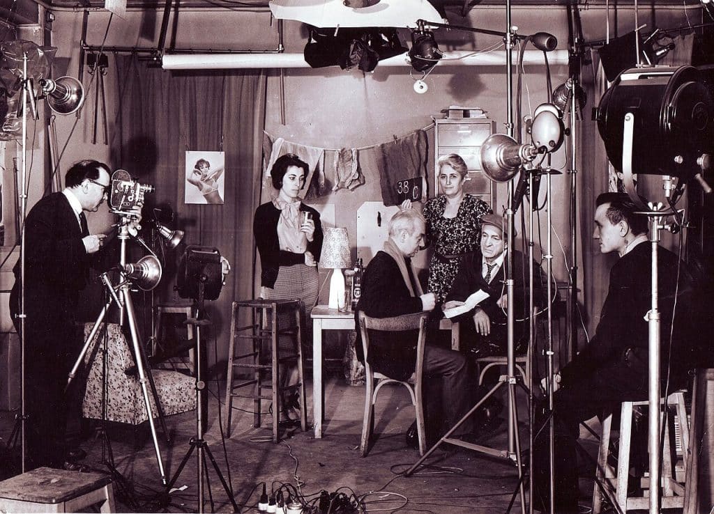 A black-and-white image showing people on a filming site