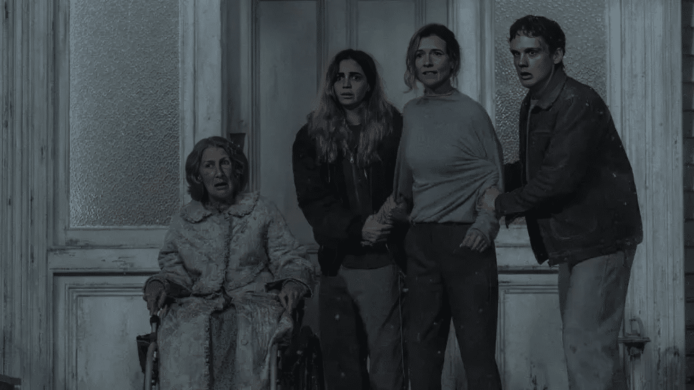 Alice, Hunter, Susan, and the grandmother stands outside of remote home.