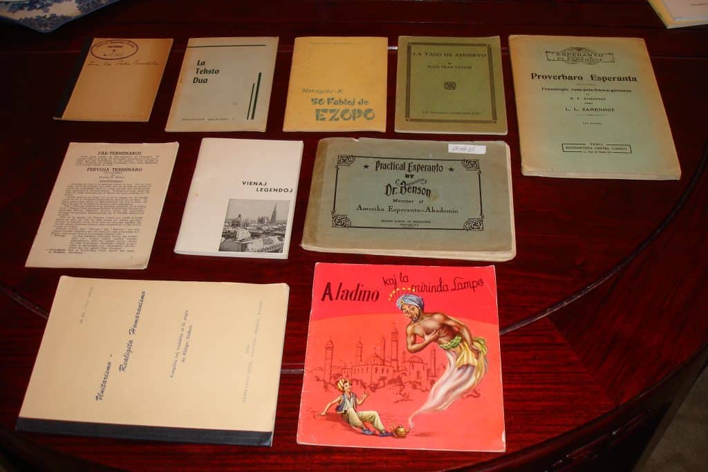 There are several Esperanto books with colorful covers on the table on this image.