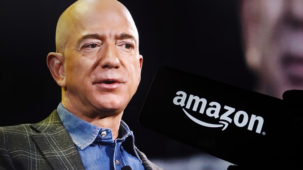 Jeff Bezos speaking at a conference, with the Amazon logo in the background.