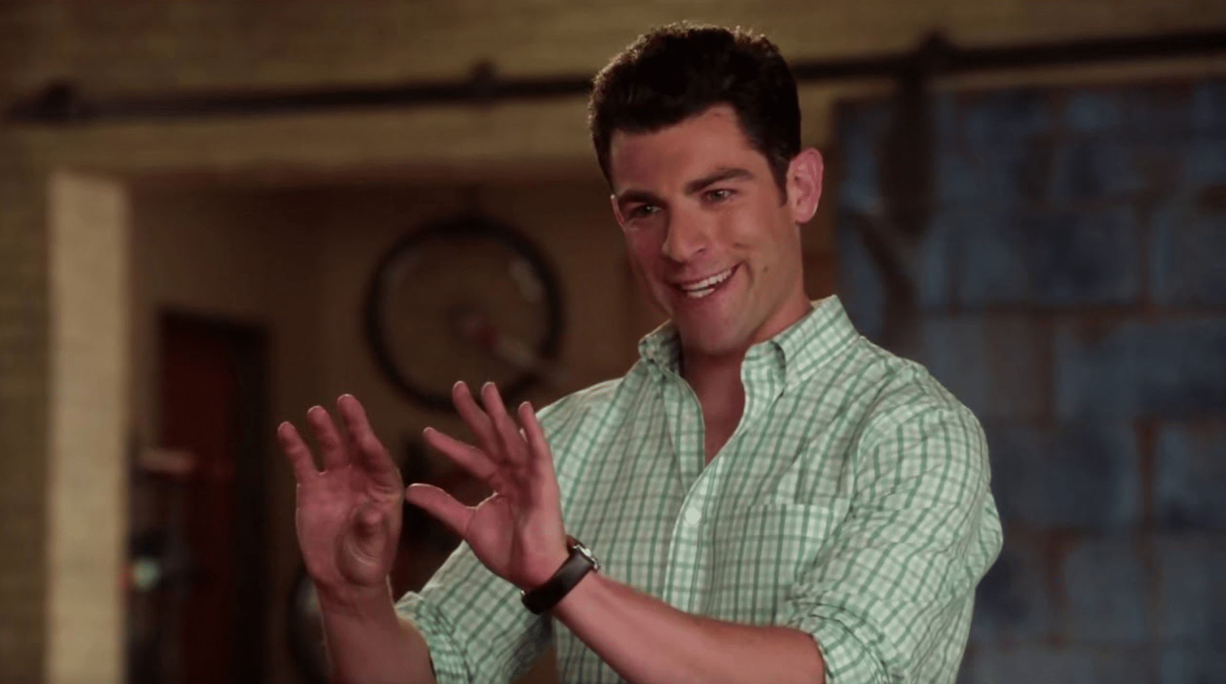 A still from "New Girl" of a man speaking while gesturing with his hands.