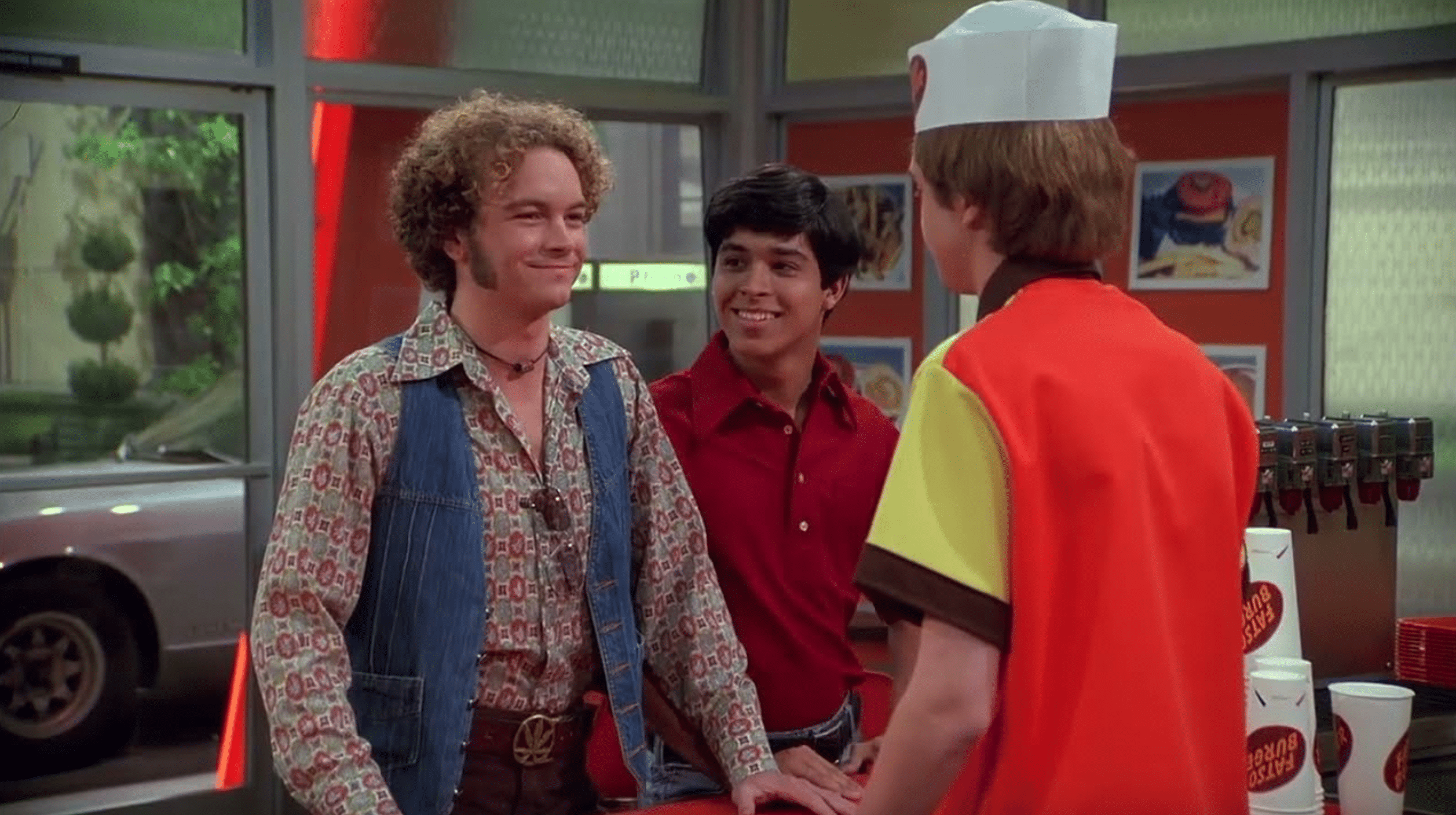 A still from "That 70s Show" of two teens ordering from another teen at a restaurant.