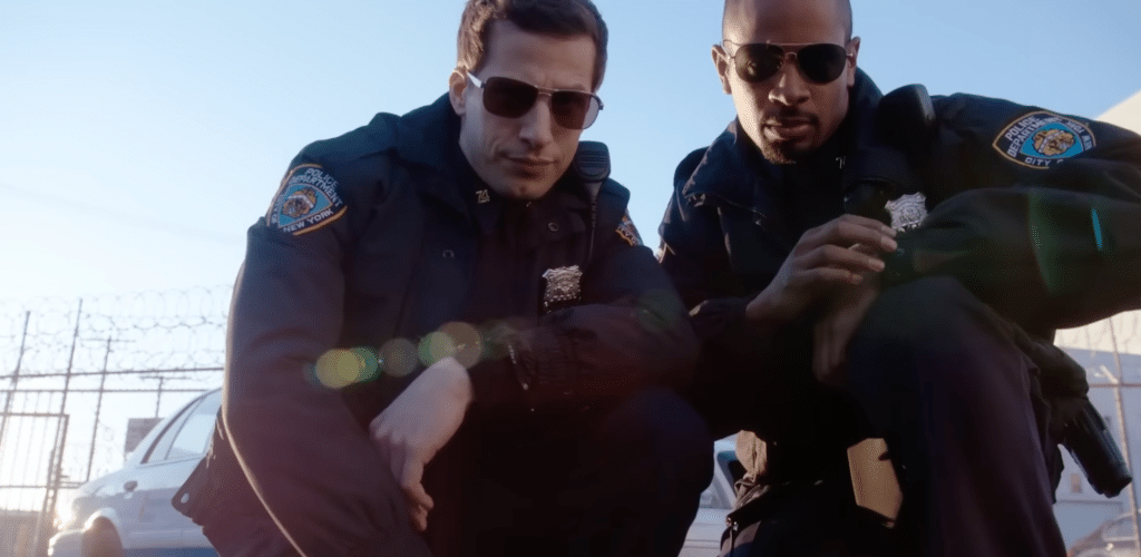 A still from "Brooklyn Nine-Nine" where two cops are squatting with sunglasses on to pose for the camera.